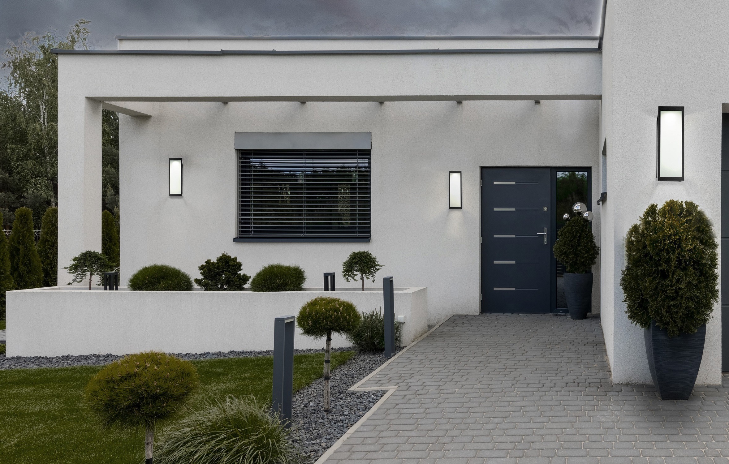 Dark Sky Compliant outdoor lighting illuminates the exterior of a modern white home.