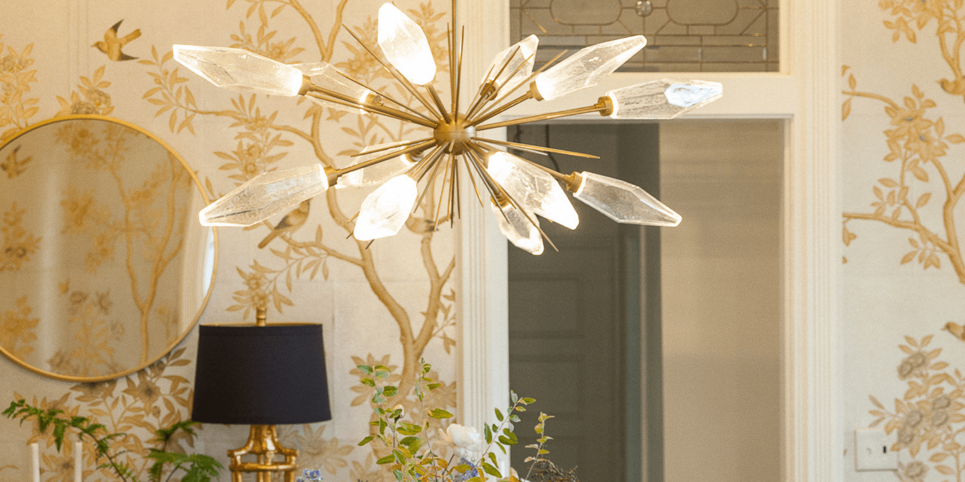 Hammerton Studio's Rock Crystal starburst chandelier features a dozen clear rock crystal-shaped glass shades extending on solid brass rods from a brass center to form a beautiful oval centerpiece