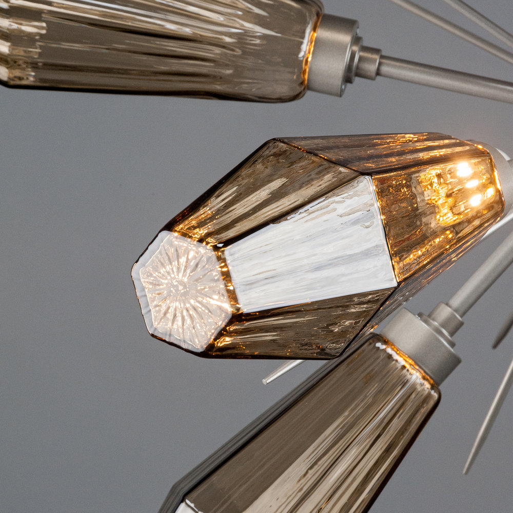 Closeup detail of a Hammerton Studio Aalto starburst chandelier with gunmetal finish and geometric crystal glass light shades.