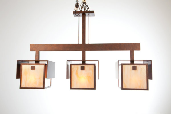  This unique suspension light, crafted from artisan glass with an antique copper finish, is stunning in its symmetry and simplicity. The fluidity and clean craftsmanship of this piece celebrates the essential ideologies of Arts &amp; Crafts design. 