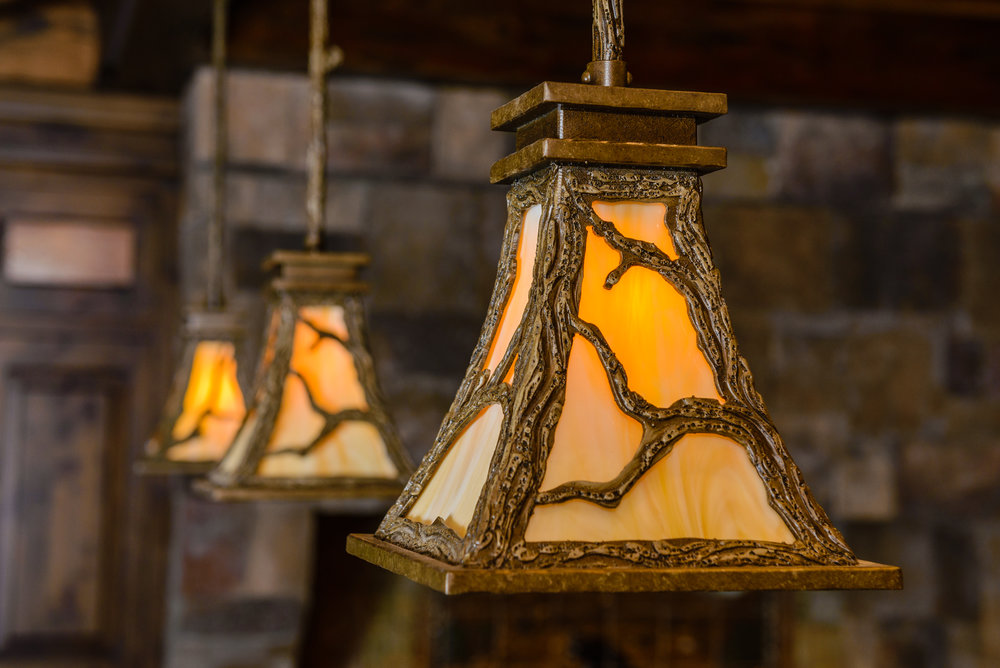 A trio of LA7130 rustic pendants feature detailed tree branch motif and wood texture.