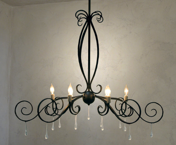  The Lightspann Lucien Chandelier offers a uniquely elegant design featuring hanging glass crystals carefully crafted to look like drops of water. The delicate nature of the droplets echo the chandelier's graceful curves and curls. 
