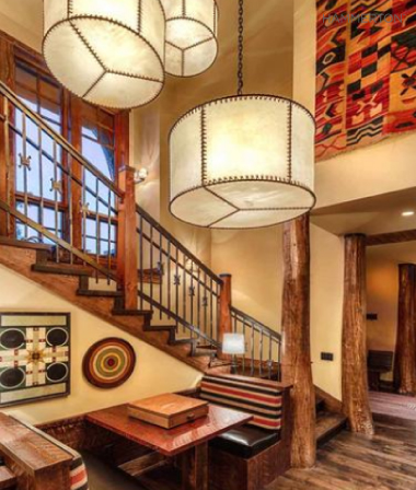  A staggered trio of lashed rawhide drum chandeliers underscores the contemporary western style of this stair landing. 