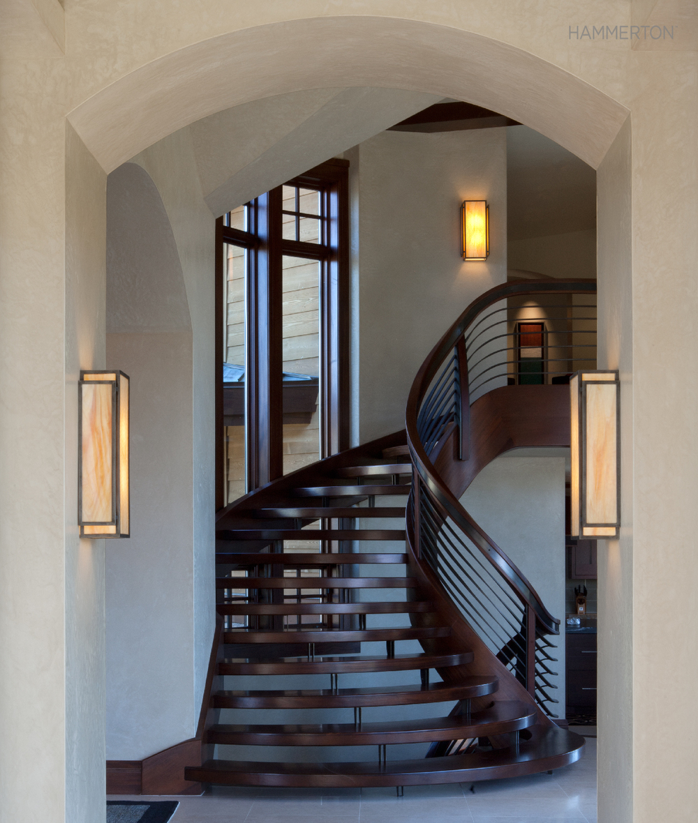 With a stairway this dramatic, a pair of quiet cover sconces at the landing is quite enough! Interiors by Leslie Schofield Design.