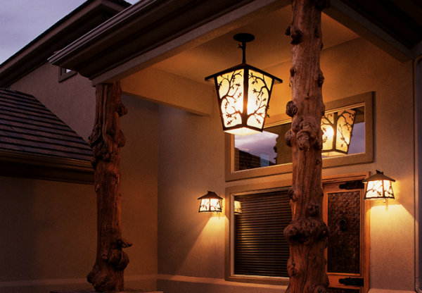 A Log & Timber chandelier with a maple branch motif and matching wall sconces coordinate perfectly with a rustic exterior.