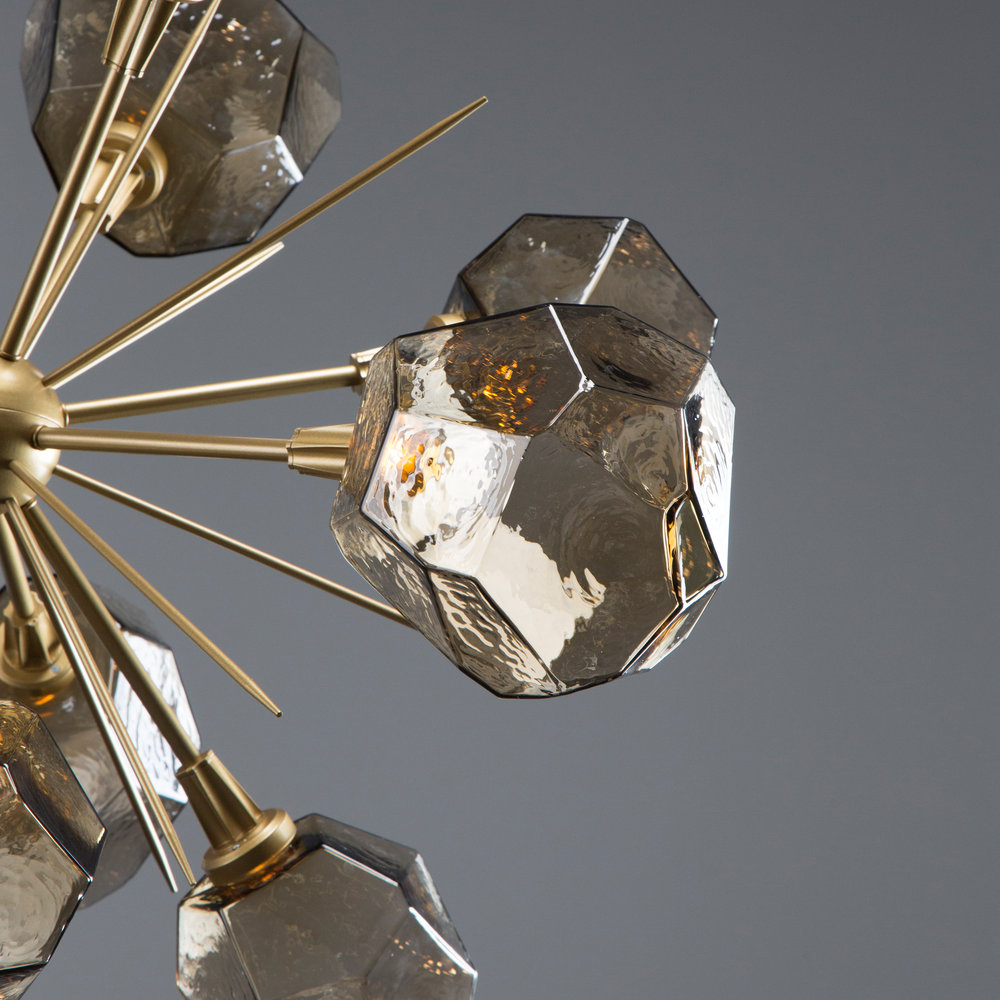 Closeup detail of a Hammerton Studio Gem sputnik chandelier with brass finish and smoky gem-shaped crystal glass light shades.