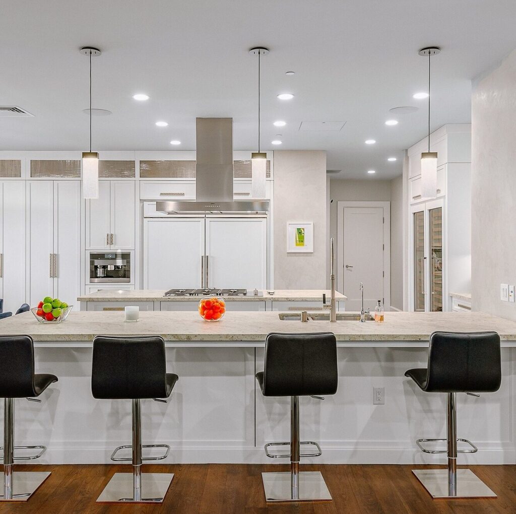 pendant lighting over the kitchen island bar featuring parallel panes of glass illuminated by LEDs for a sleek Scandinavian vibe