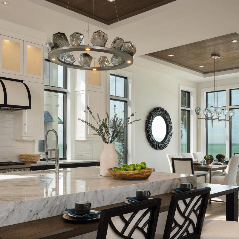 a beautiful kitchen and dining space featuring chandeliers from the Gem collection by Hammerton Studio