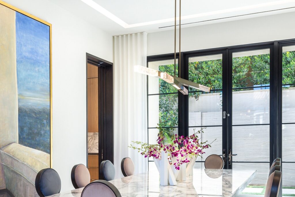A Hammerton Studio Axis Pivot Chandelier nods to sleek lines and rich textures in the dining room.